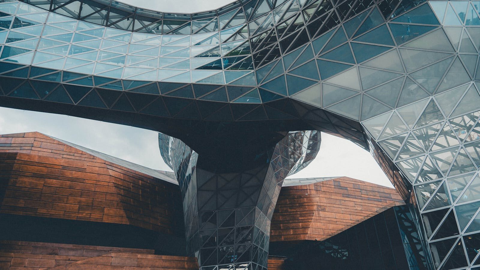 Dynamic view of a modern architectural structure featuring glass and steel elements.